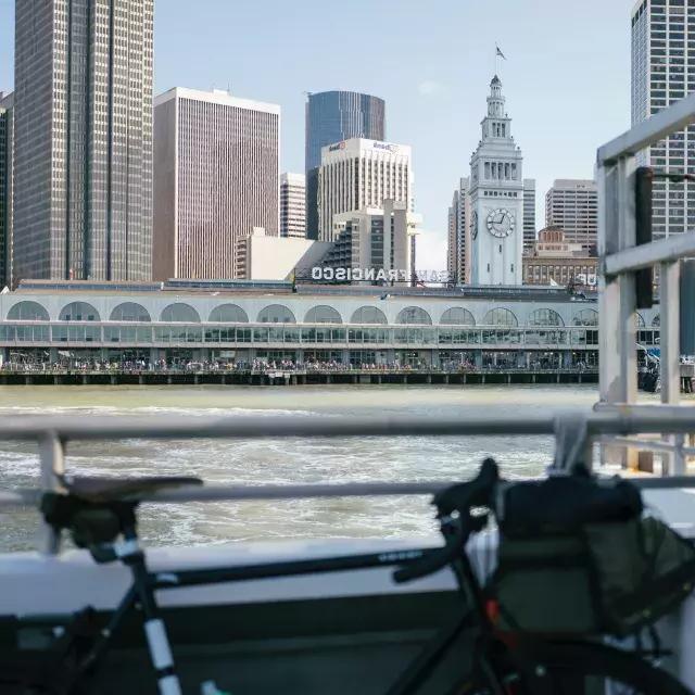 Bike leaning against a rail with the Ferry Building in the background.